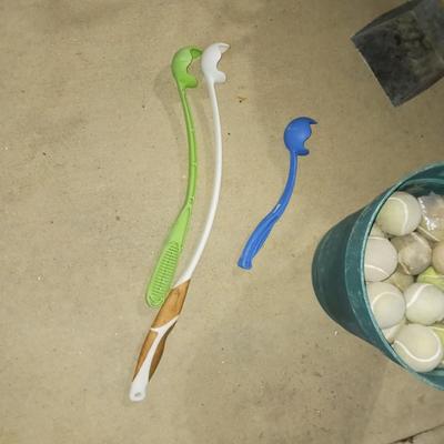 A BUCKET OF DOG TOY BALLS, THROWERS AND POOPER SCOOPER