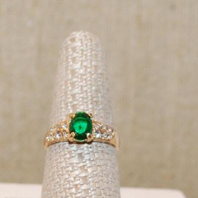 Size 8¾ Green Oval Main Stone Ring with 14 Side Clear Accents Stones on a Gold Tone Band (2.9g)