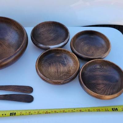 Wooden bowl with 4 salad bowls and fork and spoon