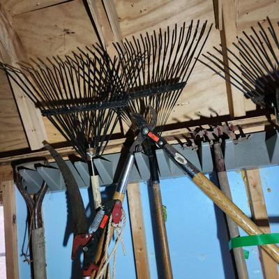 Wall of Garden Yard Tools Shovels, Racks, Small hand Tools in bucket with seat, Snow Shovels