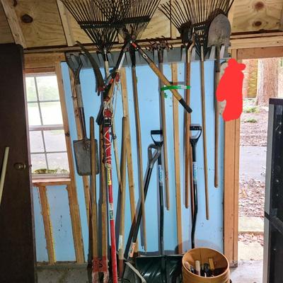 Wall of Garden Yard Tools Shovels, Racks, Small hand Tools in bucket with seat, Snow Shovels