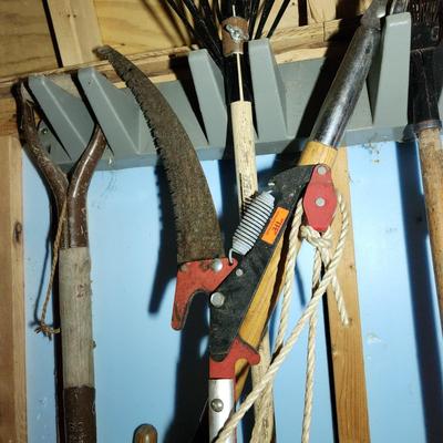 Wall of Garden Yard Tools Shovels, Racks, Small hand Tools in bucket with seat, Snow Shovels
