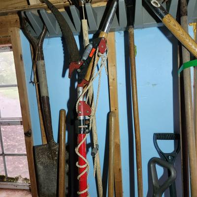 Wall of Garden Yard Tools Shovels, Racks, Small hand Tools in bucket with seat, Snow Shovels