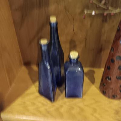 3 BLUE CORKED BOTTLES AND A CERAMIC VASE WITH FAUX FOLIAGE