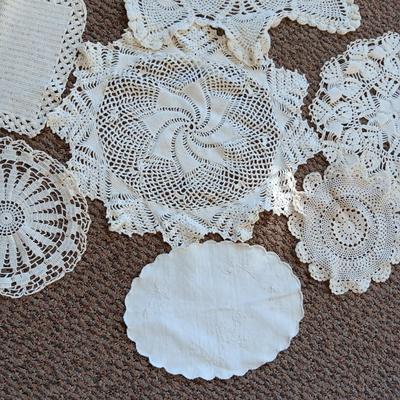 A LARGE AMOUNT OF LACEY MATERIAL AND HANDMADE DOILIES
