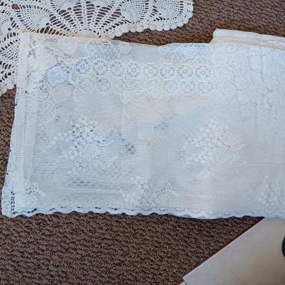 A LARGE AMOUNT OF LACEY MATERIAL AND HANDMADE DOILIES