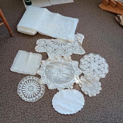 A LARGE AMOUNT OF LACEY MATERIAL AND HANDMADE DOILIES