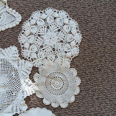 A LARGE AMOUNT OF LACEY MATERIAL AND HANDMADE DOILIES