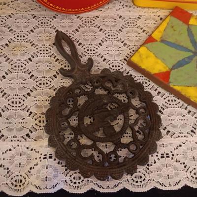 2 CAST IRON TRIVETS, CLAY HOT PLATE AND TINS