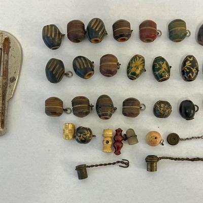 Sale Photo Thumbnail #214: This assortment includes antique Burmese beads, Mid Century Modern French pilsner glasses, thumb guitar, and a ornately carved jewelry box. Total of 30 plus pieces. Measurement of largest: 8"H. [LV]