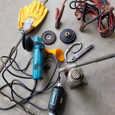 Sale Photo Thumbnail #710: 6 ton bottle jack, jumper cables, vintage corded makita angle grinder, with 2 buffing pads, electric chain saw sharpener,  what I believe is an adjustable filter wrench.
In garage