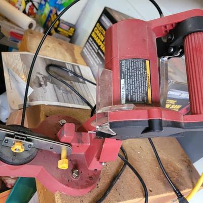 Chain saw sharpener with original box and manual on stand