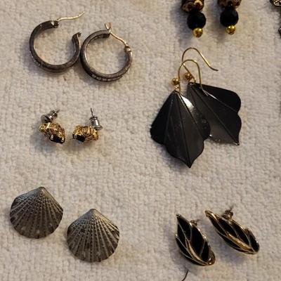 A COLLECTION OF PIERCED EARRINGS AND A ROTATING EARRING HOLDER