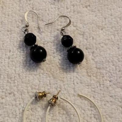 A COLLECTION OF PIERCED EARRINGS AND A ROTATING EARRING HOLDER
