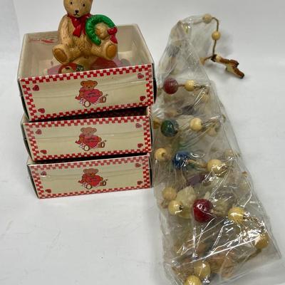 Sale Photo Thumbnail #118: Lot includes 3 teddy bear ornaments and a seated teddy bear figurine, and a package of twine garland with beads and Christmas figures. All in good condition.