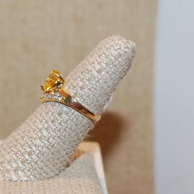 Size 7 Yellow Colored Round Stone Ring with a "V" Clear Stone Accent on a Gold Tone Band (2.6g)