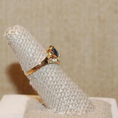 Size 6¾ Deep Purple Round Main Stone Ring with a "V" Clear Stone Accent on a Gold Tone Band (2.7g)