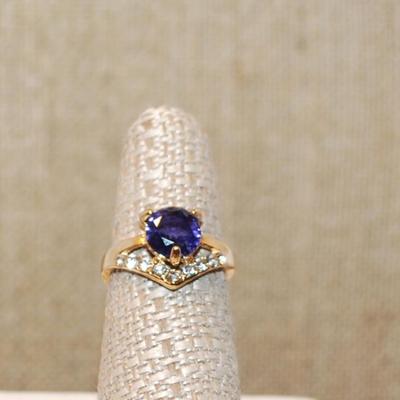 Size 6¾ Deep Purple Round Main Stone Ring with a "V" Clear Stone Accent on a Gold Tone Band (2.7g)