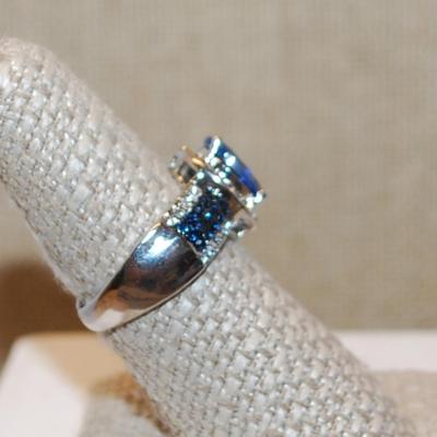 Size 8 Deep Blue Oval Main Stone Ring with Clear & Blue Line Accents on a Silver Tone Band (5.6g)