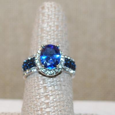 Size 8 Deep Blue Oval Main Stone Ring with Clear & Blue Line Accents on a Silver Tone Band (5.6g)