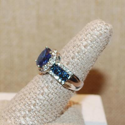 Size 8 Deep Blue Oval Main Stone Ring with Clear & Blue Line Accents on a Silver Tone Band (5.6g)