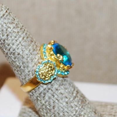 Size 7¼ Large Blue Transparent Stone Ring with Blue Side Accents on a Gold Tone Band (5.4g)