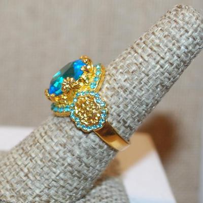 Size 7¼ Large Blue Transparent Stone Ring with Blue Side Accents on a Gold Tone Band (5.4g)