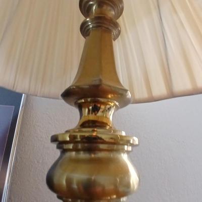 Brass colored table lamp with framed artwork of pink roses