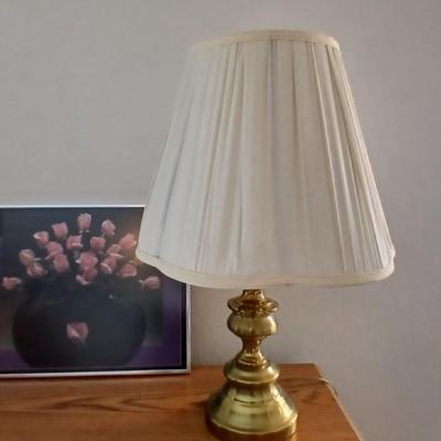 Brass colored table lamp with framed artwork of pink roses