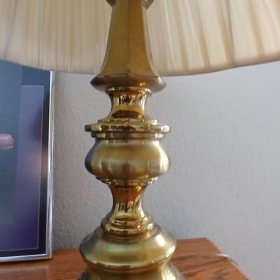 Brass colored table lamp with framed artwork of pink roses