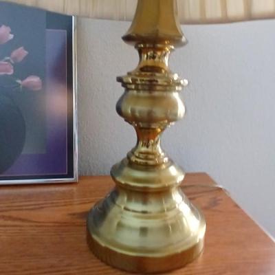 Brass colored table lamp with framed artwork of pink roses