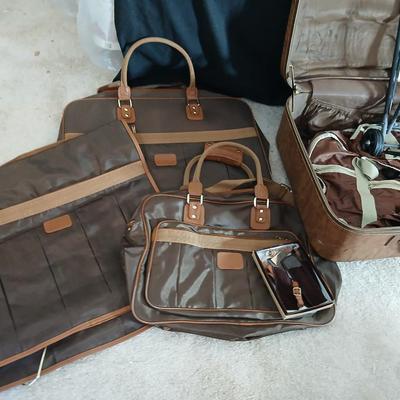 Suitcase with an assortment of bags and a two wheeled adjustable luggage cart