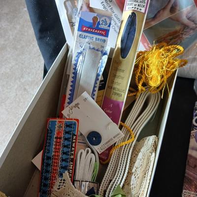 Skeins of yarn, new zippers, stretch lace edging, and other crafting / sewing items