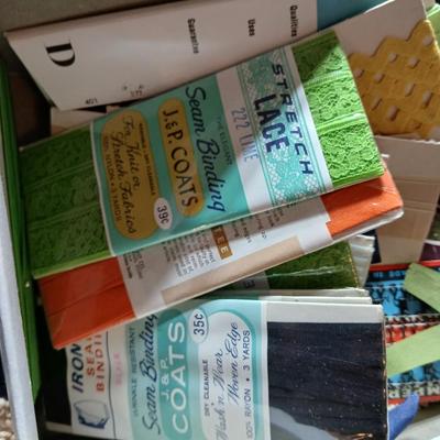 Skeins of yarn, new zippers, stretch lace edging, and other crafting / sewing items