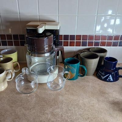 Like new 12 cup Hamilton beach coffee maker with all these coffee mugs sugar & cream dishes too!