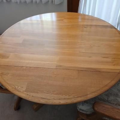 Beautiful drop leaf Oak pedestal table with three upholstered chairs on casters