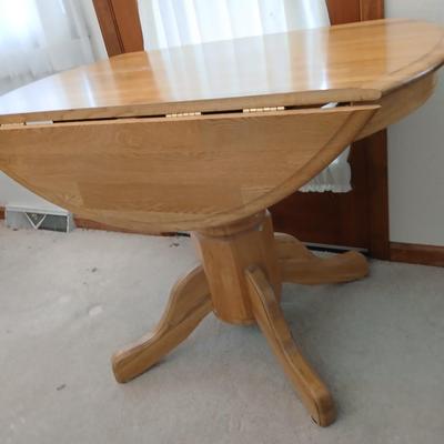 Beautiful drop leaf Oak pedestal table with three upholstered chairs on casters