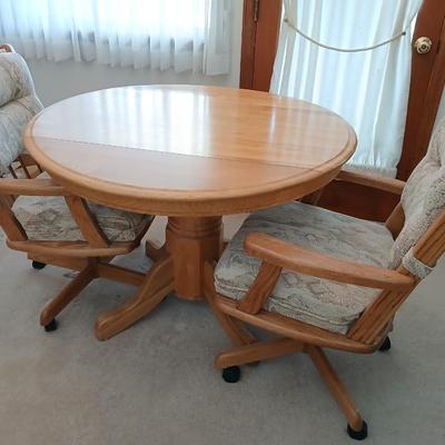 Beautiful drop leaf Oak pedestal table with three upholstered chairs on casters