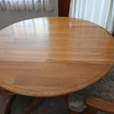 Beautiful drop leaf Oak pedestal table with three upholstered chairs on casters