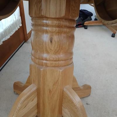 Beautiful drop leaf Oak pedestal table with three upholstered chairs on casters