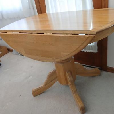 Beautiful drop leaf Oak pedestal table with three upholstered chairs on casters