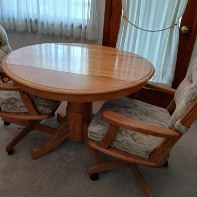 Beautiful drop leaf Oak pedestal table with three upholstered chairs on casters