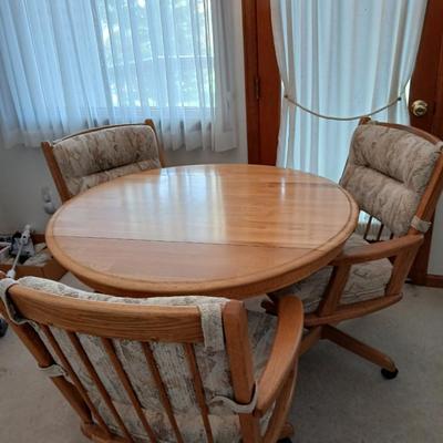 Beautiful drop leaf Oak pedestal table with three upholstered chairs on casters