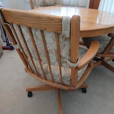 Beautiful drop leaf Oak pedestal table with three upholstered chairs on casters