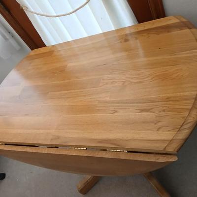 Beautiful drop leaf Oak pedestal table with three upholstered chairs on casters
