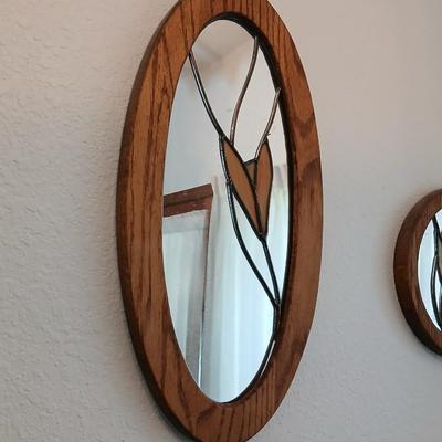 Two oak framed stained glass like wall mirrors