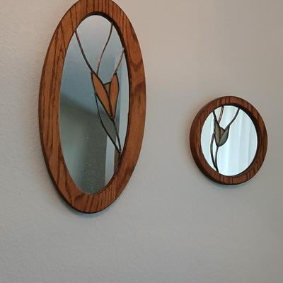 Two oak framed stained glass like wall mirrors