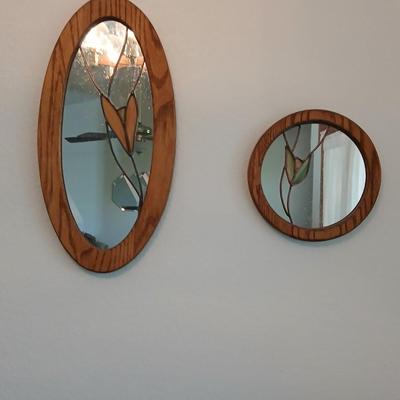 Two oak framed stained glass like wall mirrors
