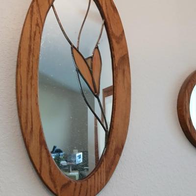 Two oak framed stained glass like wall mirrors