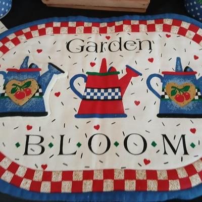 Two Garden Bloom placemats with fabric handmade apples in a basket, and mugs with a spoon rest